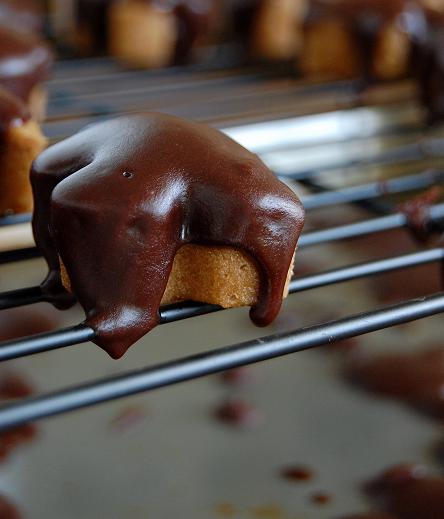 Mini Gingerbread Men Cakes on a rack with the glaze dripping down.