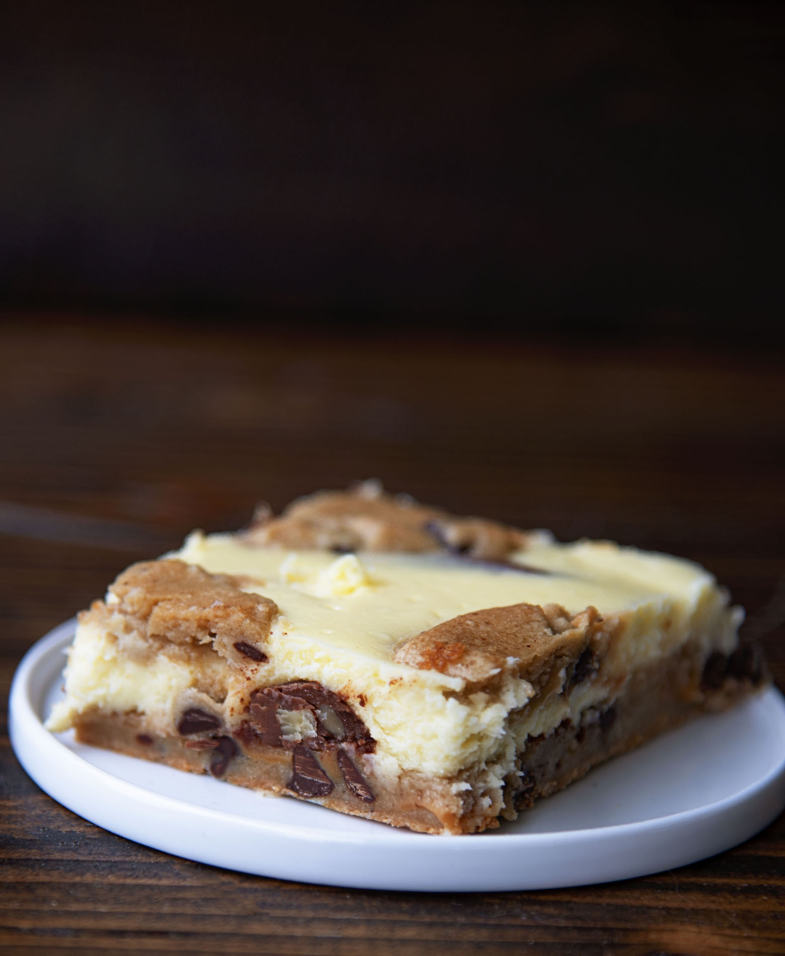 Single Caramel Turtle Cheesecake Bar on a small white plate