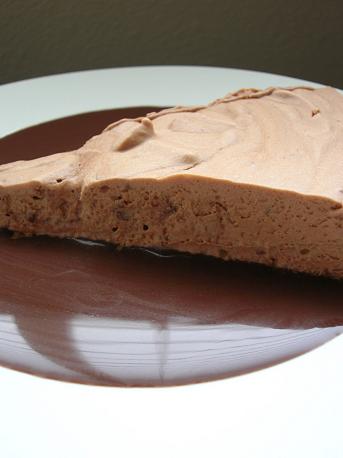 Side view of the Velvet Chocolate Torte on a plate covered in chocolate sauce