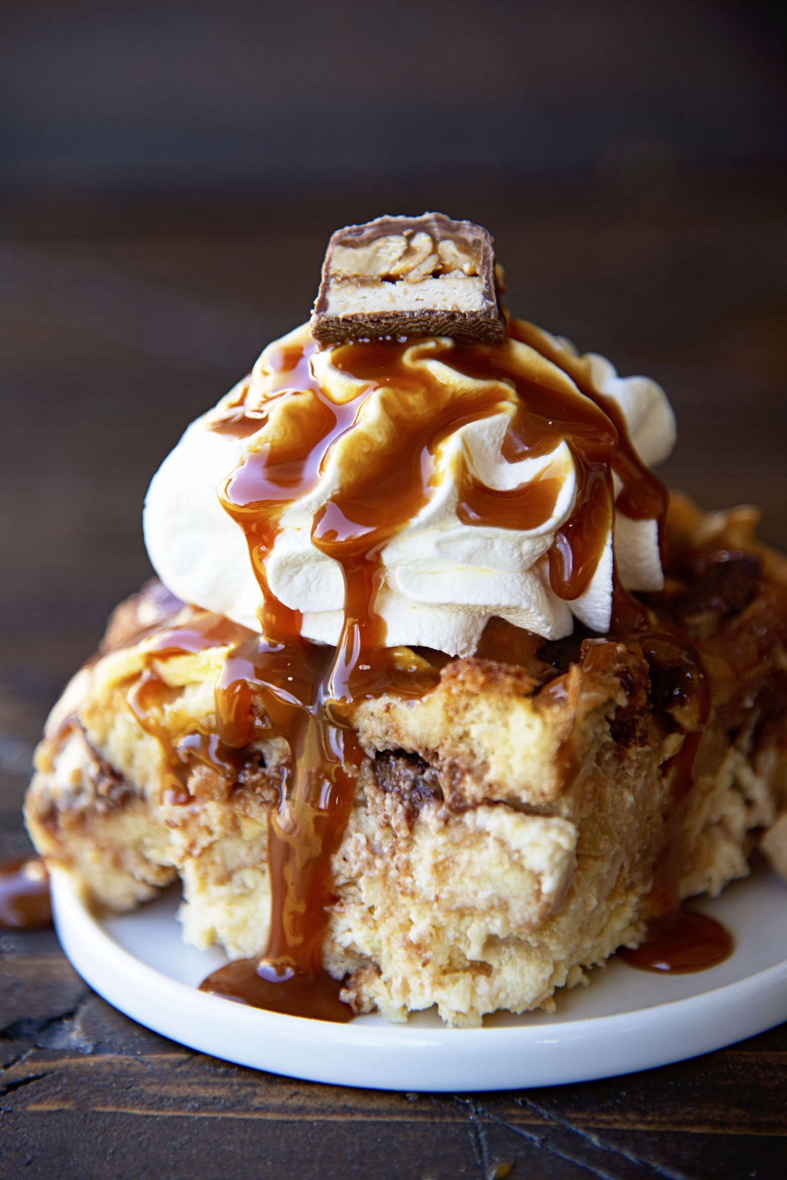 Close up of caramel dripping off of a slice of the bread pudding. 