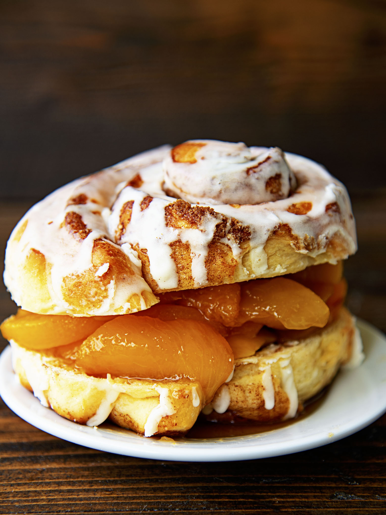 Side view of shortcake with the peaches poking out of the cinnamon roll. 