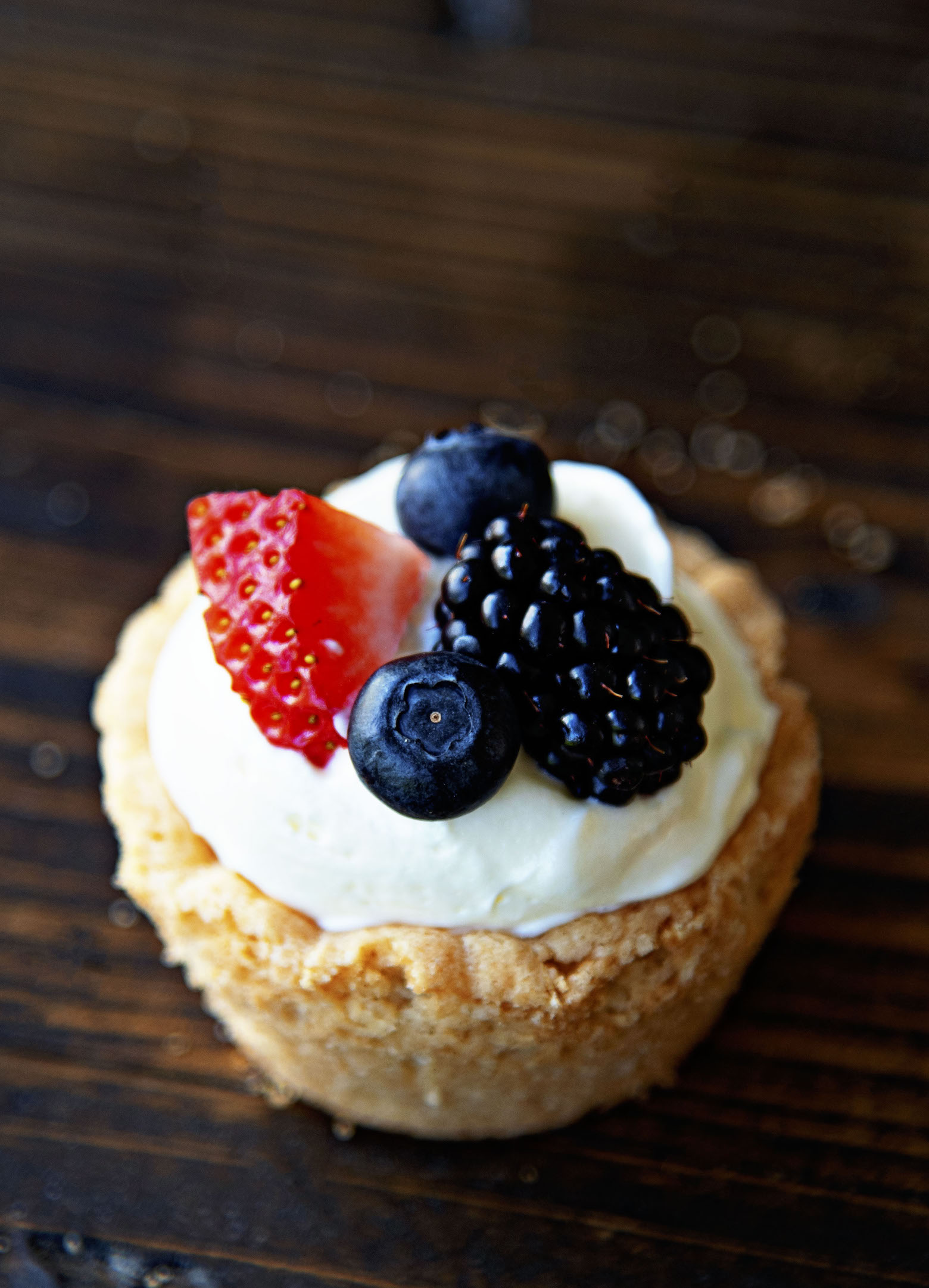 Single Fruit Pizza Pudding Shot with focus on the strawberry and blackberry on top of the pudding shot