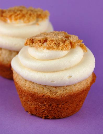 Two Honey Peanut Butter Crunch Cupcakes  with one in front of the other with purple background.