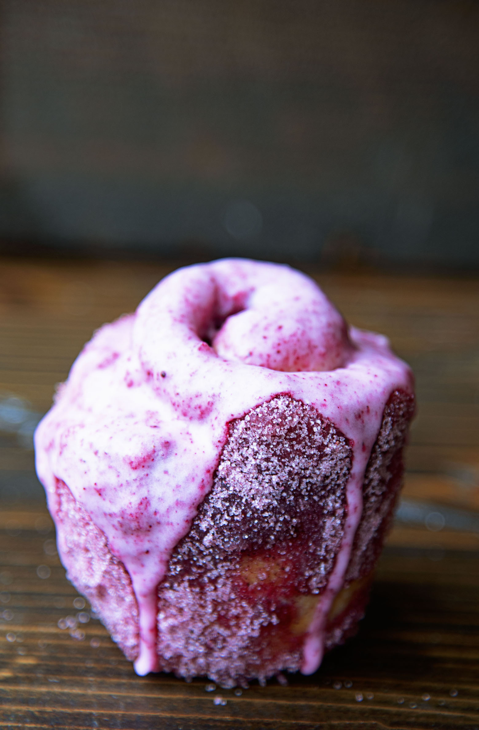 A single Kir Royale Sugar Bun with glaze dripping down it.