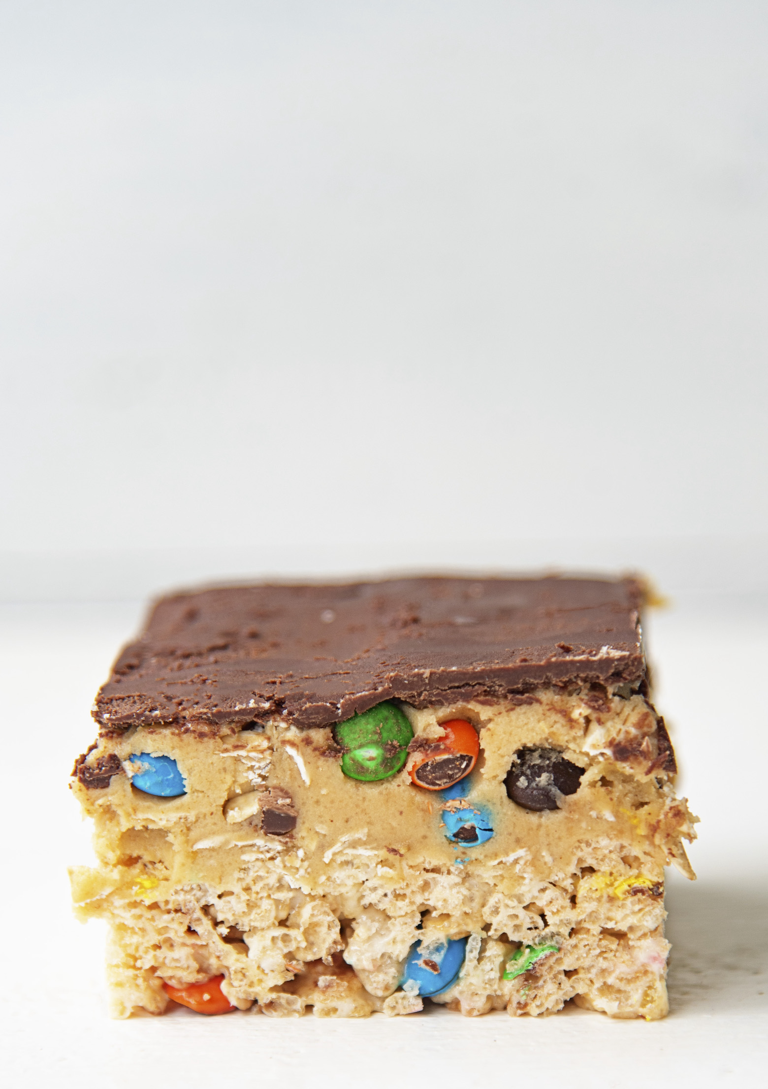 Single Monster Cookie Dough Rice Krispie Treat with a close up of the layers. 