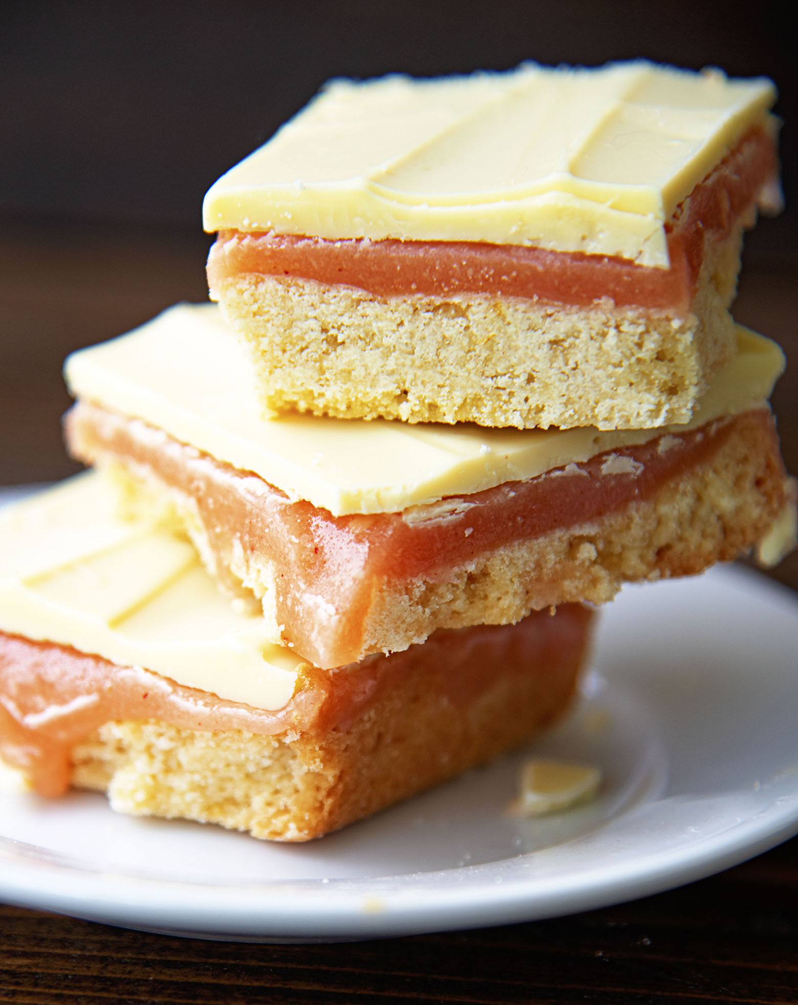 Three Strawberry Lemonade Caramel Bars stacked on top of each other with caramel oozing out of the bars. 