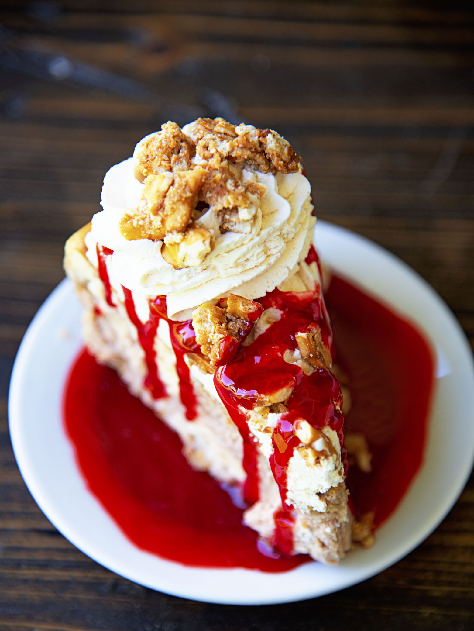Overhead shot of a slice of Strawberry Pretzel Crusted Cheesecake with focus on the top of the cheesecake. 