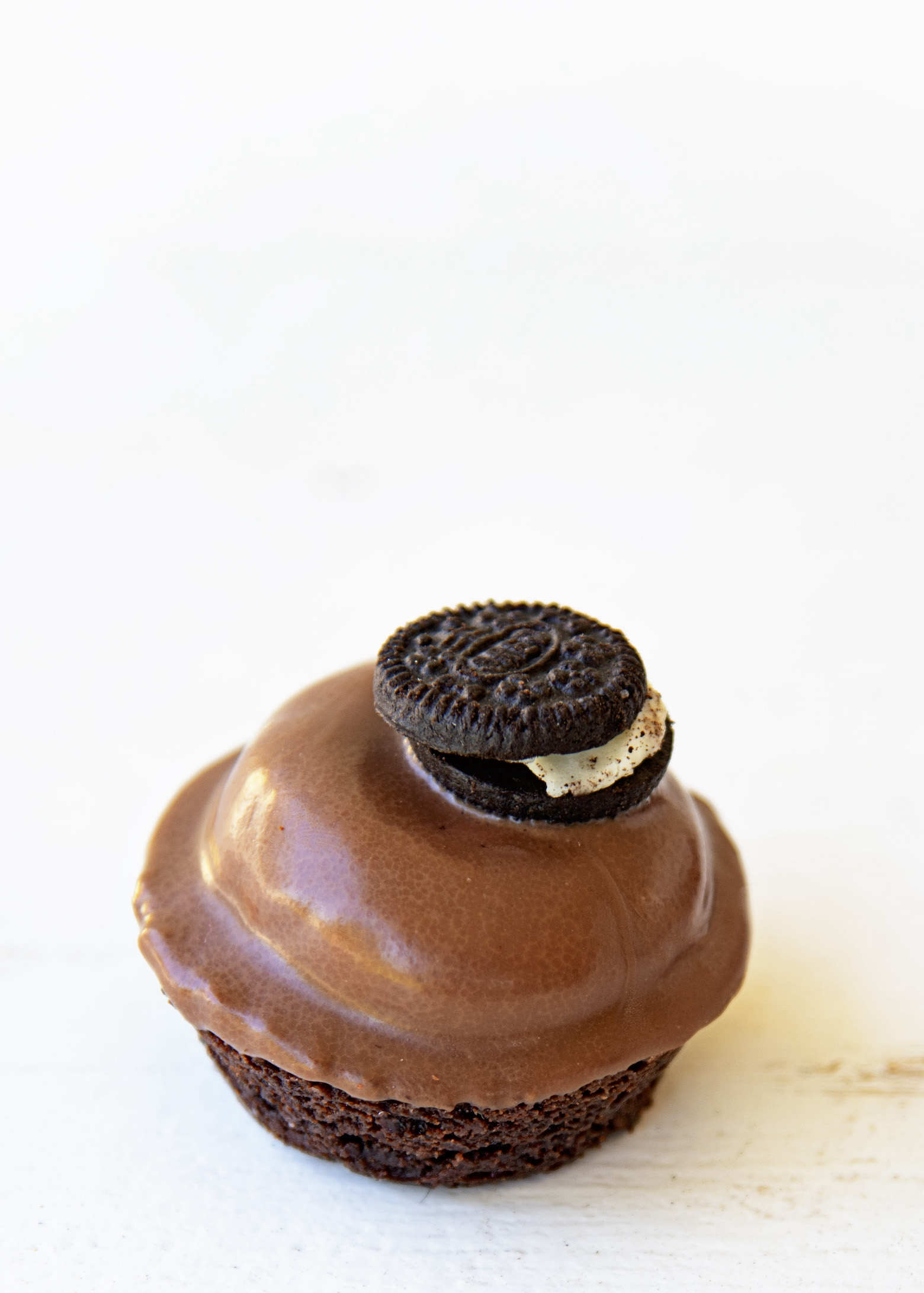 Single brownie bite, whole, with the focus on the mini Oreo on top.