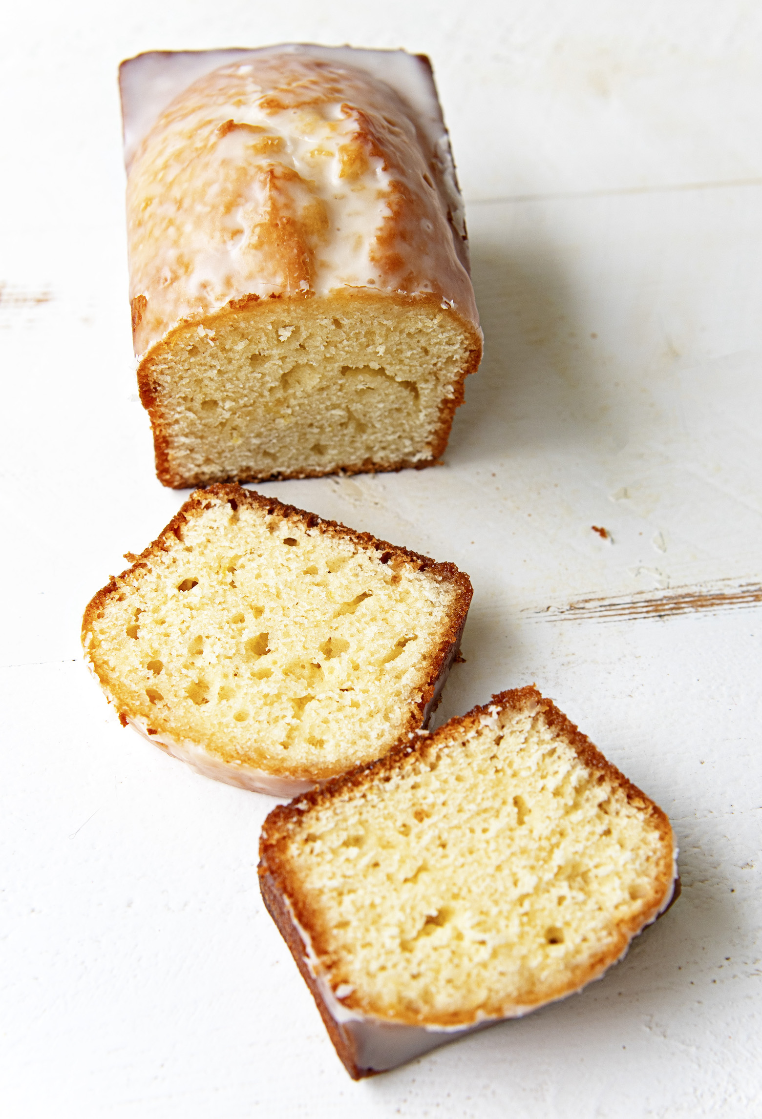 Cut Sweet Tea Glazed Lemon Loaf with two cut slices out in front of the remaining loaf. 