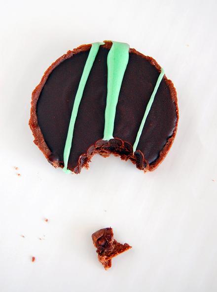 Overhead shot of the Chocolate Mint Grasshopper Tart with stripes of green marshmallow across the chocolate portion of the tart and has a bit out of it. 