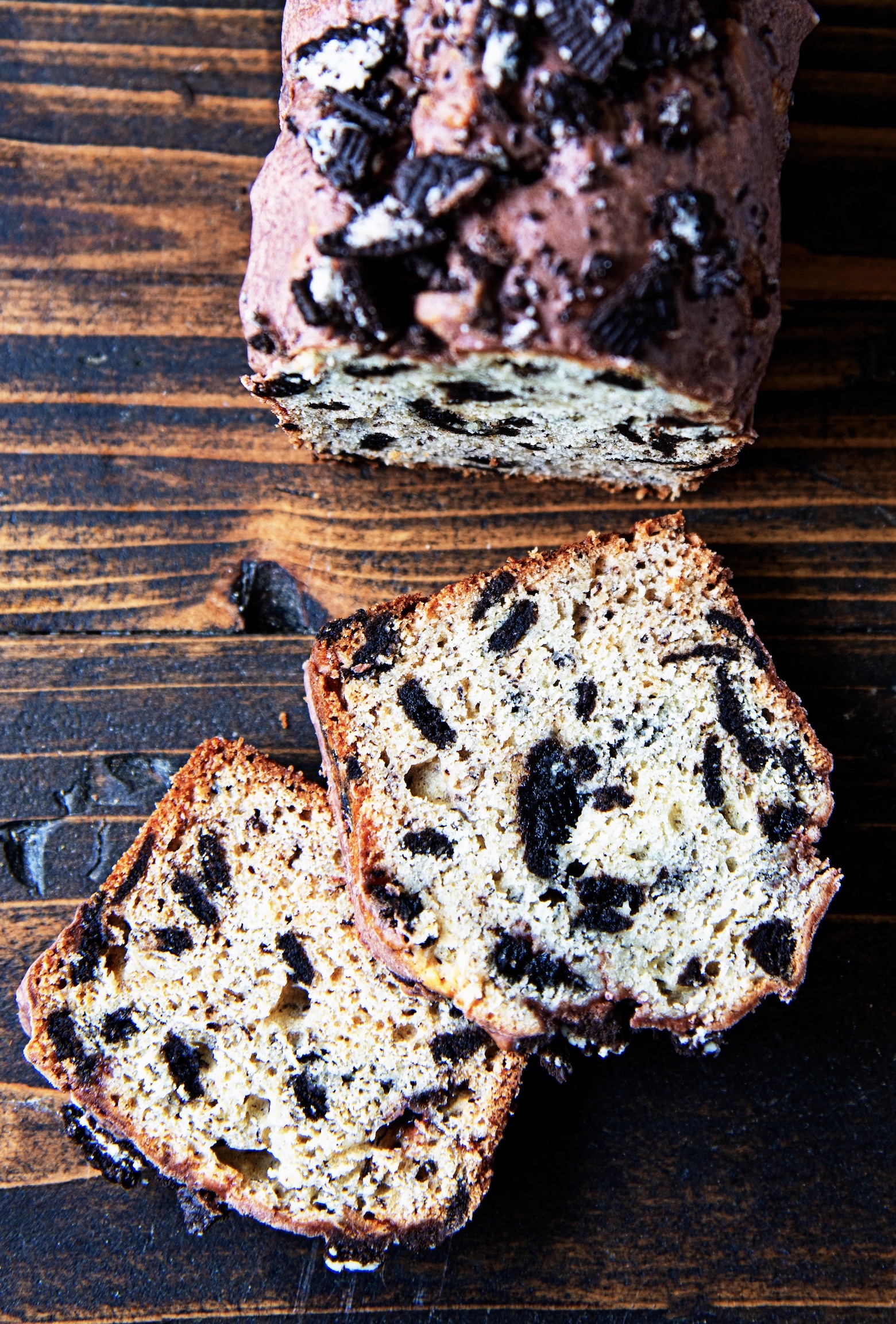 Overhead shot of cookies and cream banana bread with two slices out front of the remaining loaf.