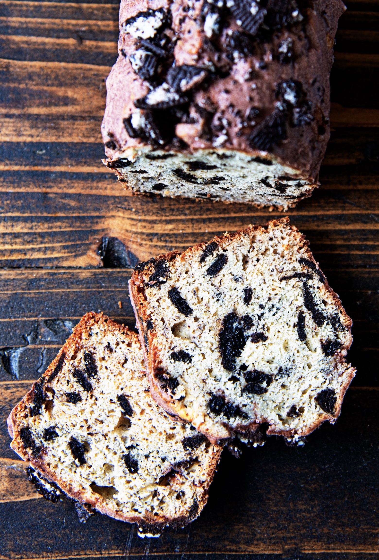 Overhead shot of cookies and cream banana bread with two slices out front of the remaining loaf. 