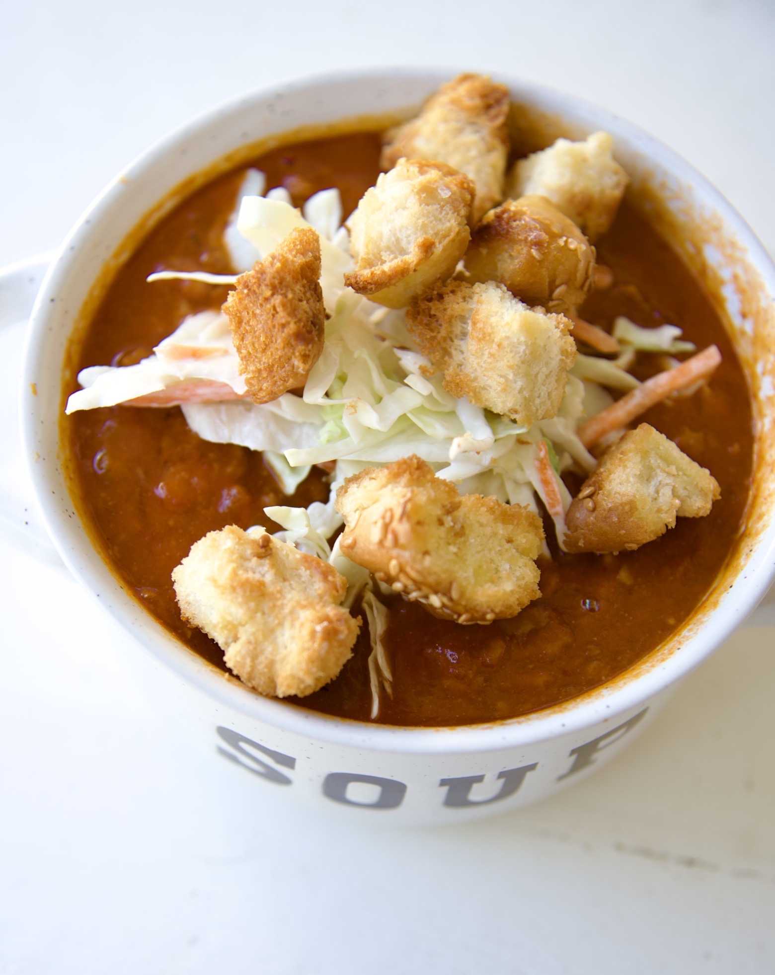Overhead shot of the soup with croutons and coleslaw piled on top. 