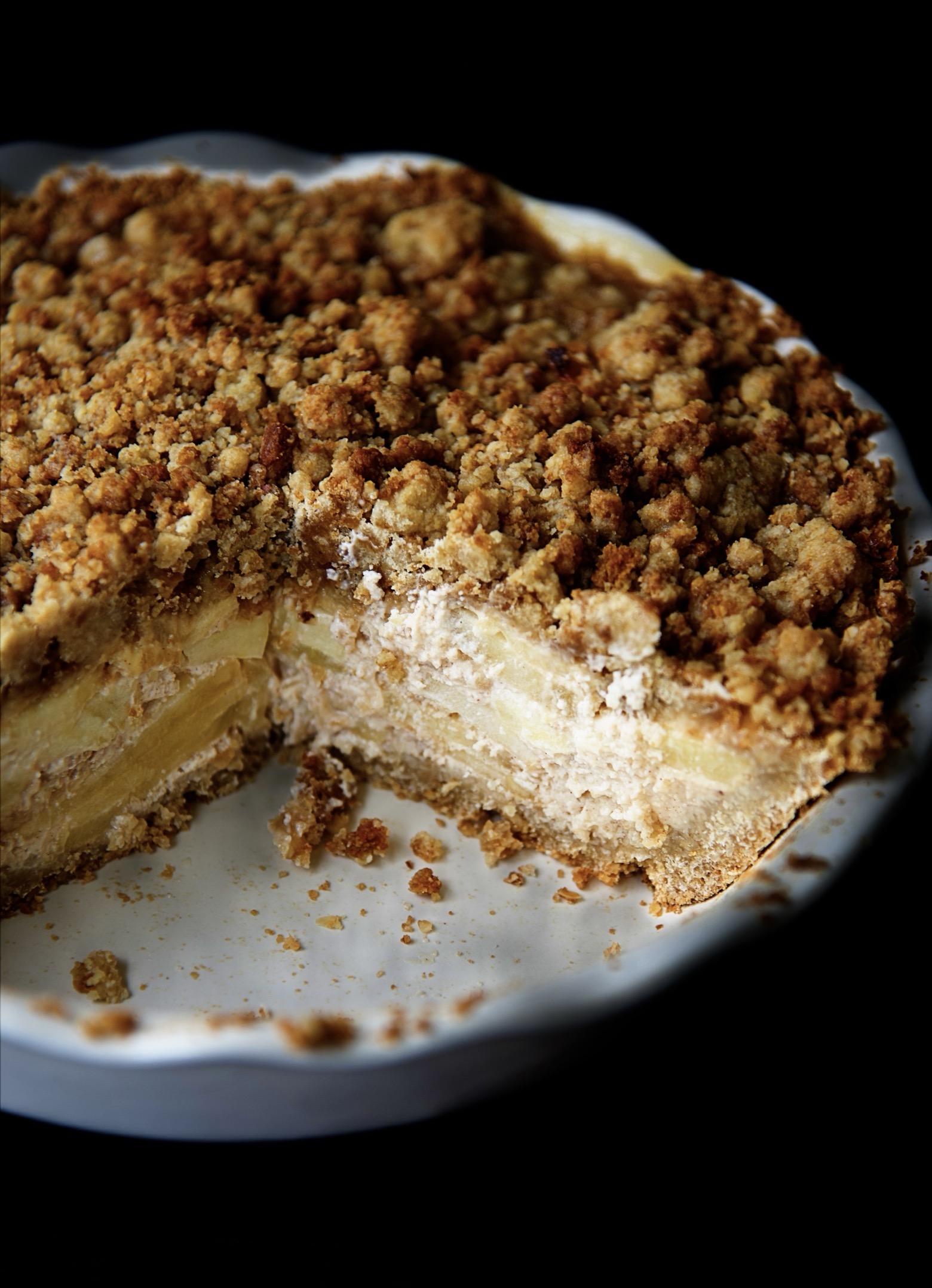 Close up of the cut pie in the dish showing the layers of the apples in the filling. 