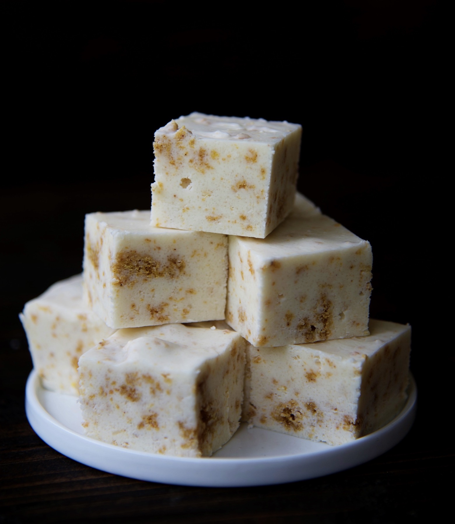 Pumpkin roll fudge piled onto a small white plate. 