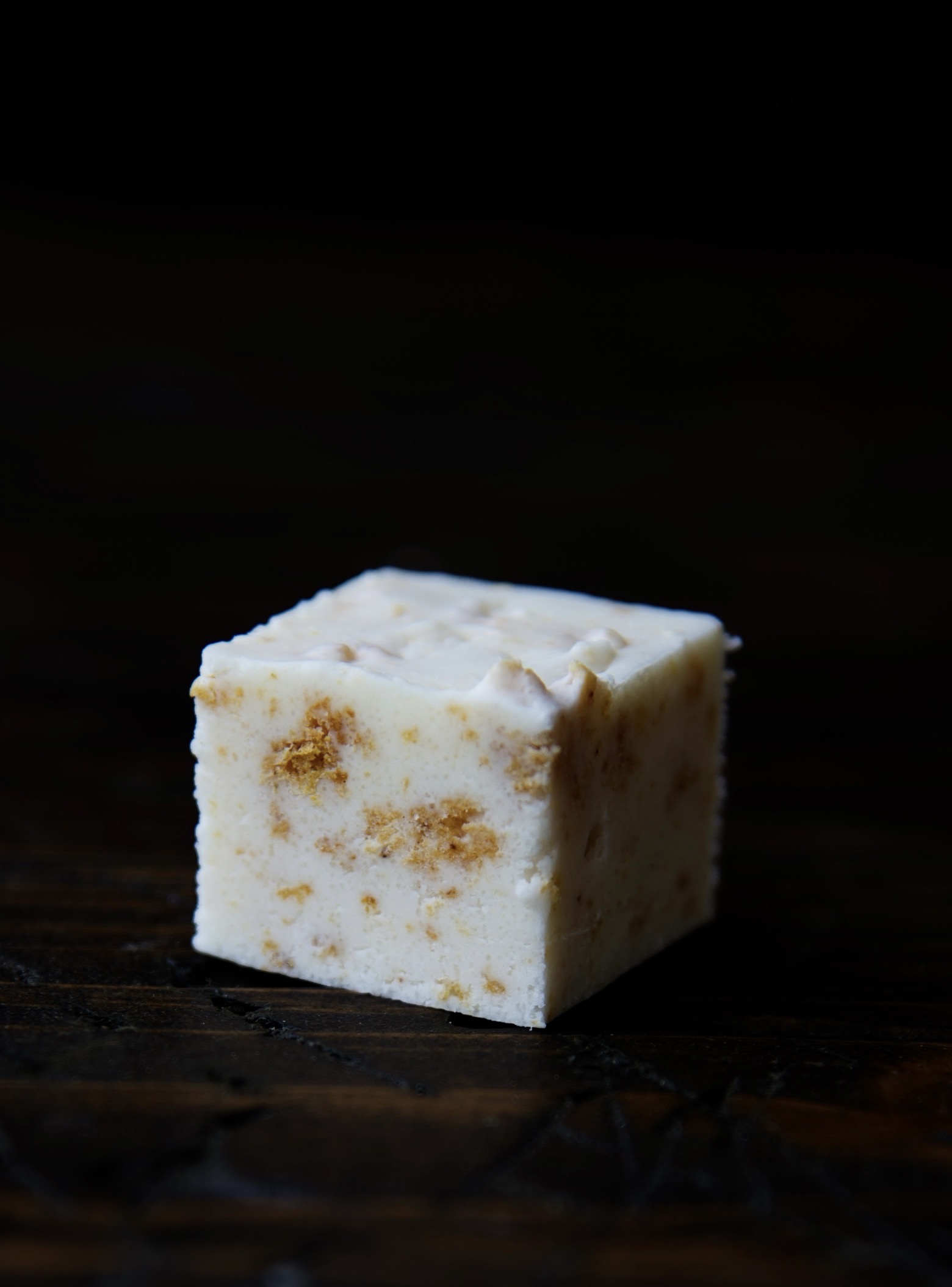 Single piece of Pumpkin Roll Fudge with the close up of the pumpkin pieces in the fudge.