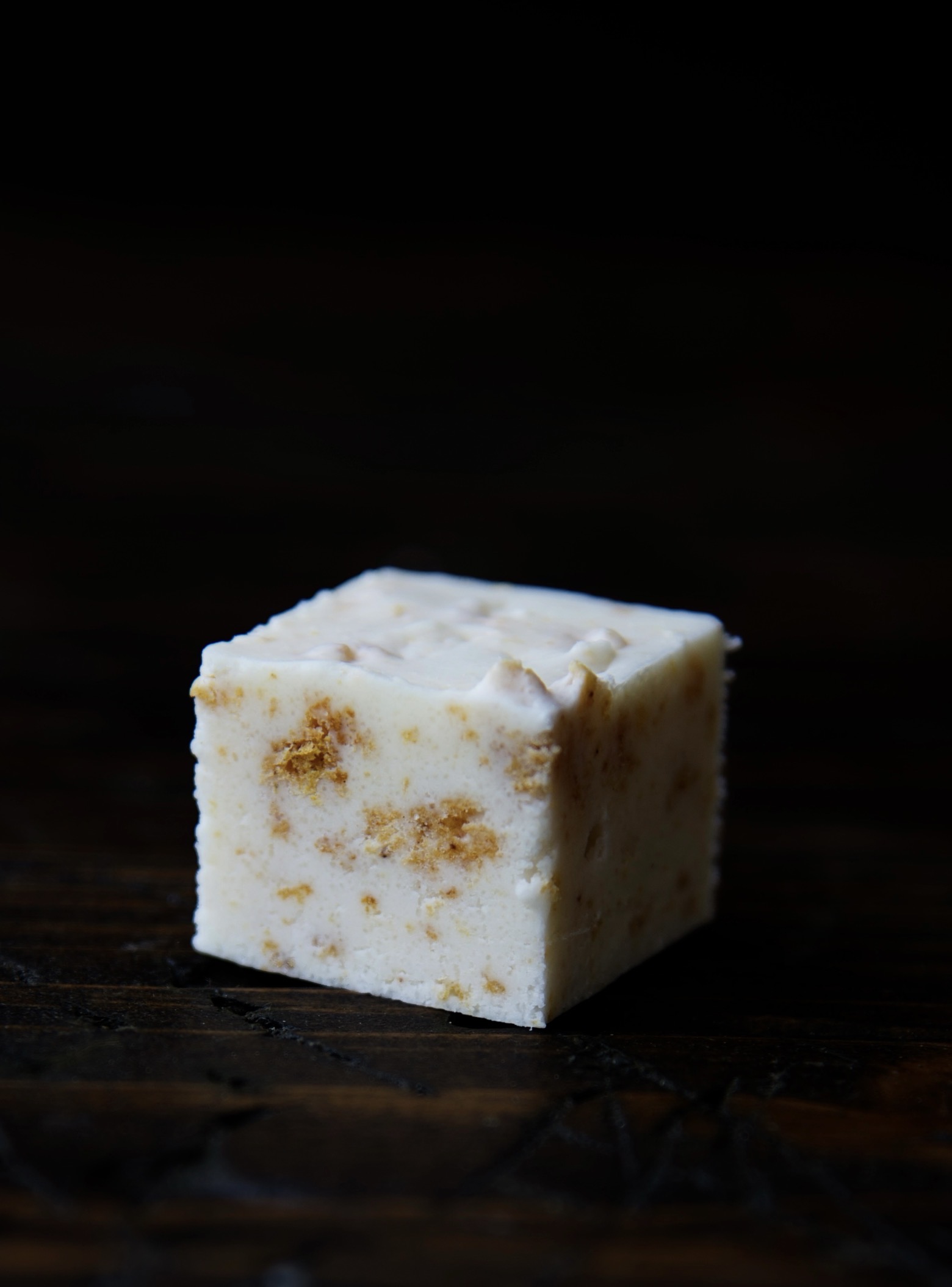 Single piece of Pumpkin Roll Fudge with the close up of the pumpkin pieces in the fudge. 