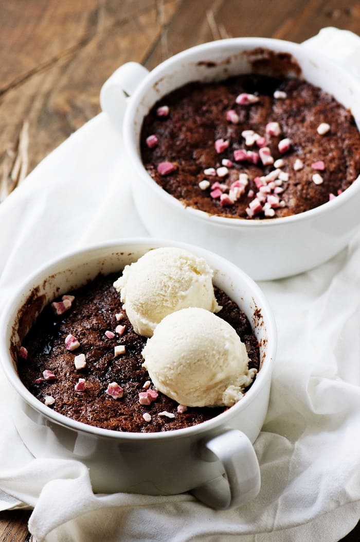 Two Chocolate Peppermint Crunch Cobblers with the first one being in focus. The first cobbler has two scoops of vanilla ice cream on top. The second one does not. 