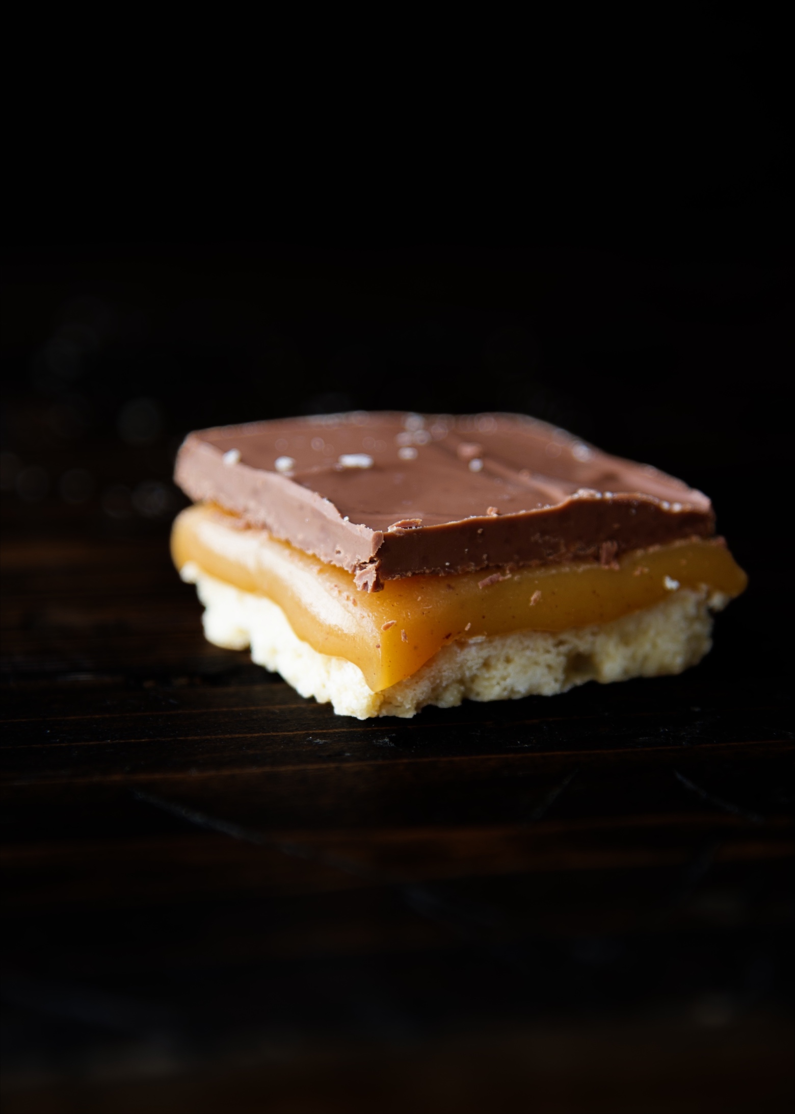 A single Eggnog Millionaire Shortbread Bar with focus on the corner of the bar. 